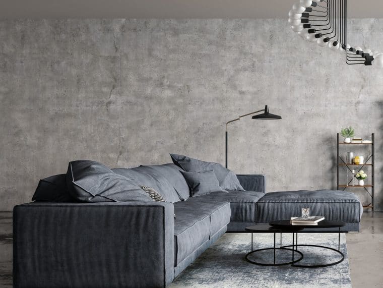 Modern interior design of a living room in an apartment, house, office, comfortable sofa, bright modern interior details and light from the window on the background of a concrete wall and floor with reflection.